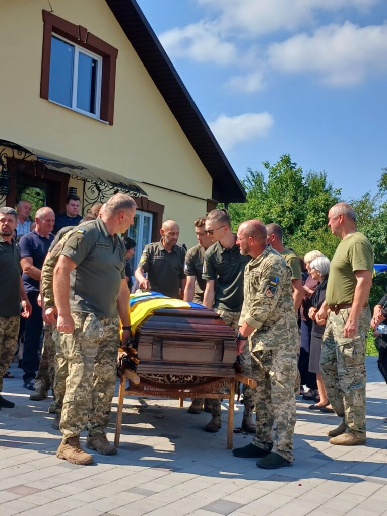 Українські військові на похороні, труна з прапором.