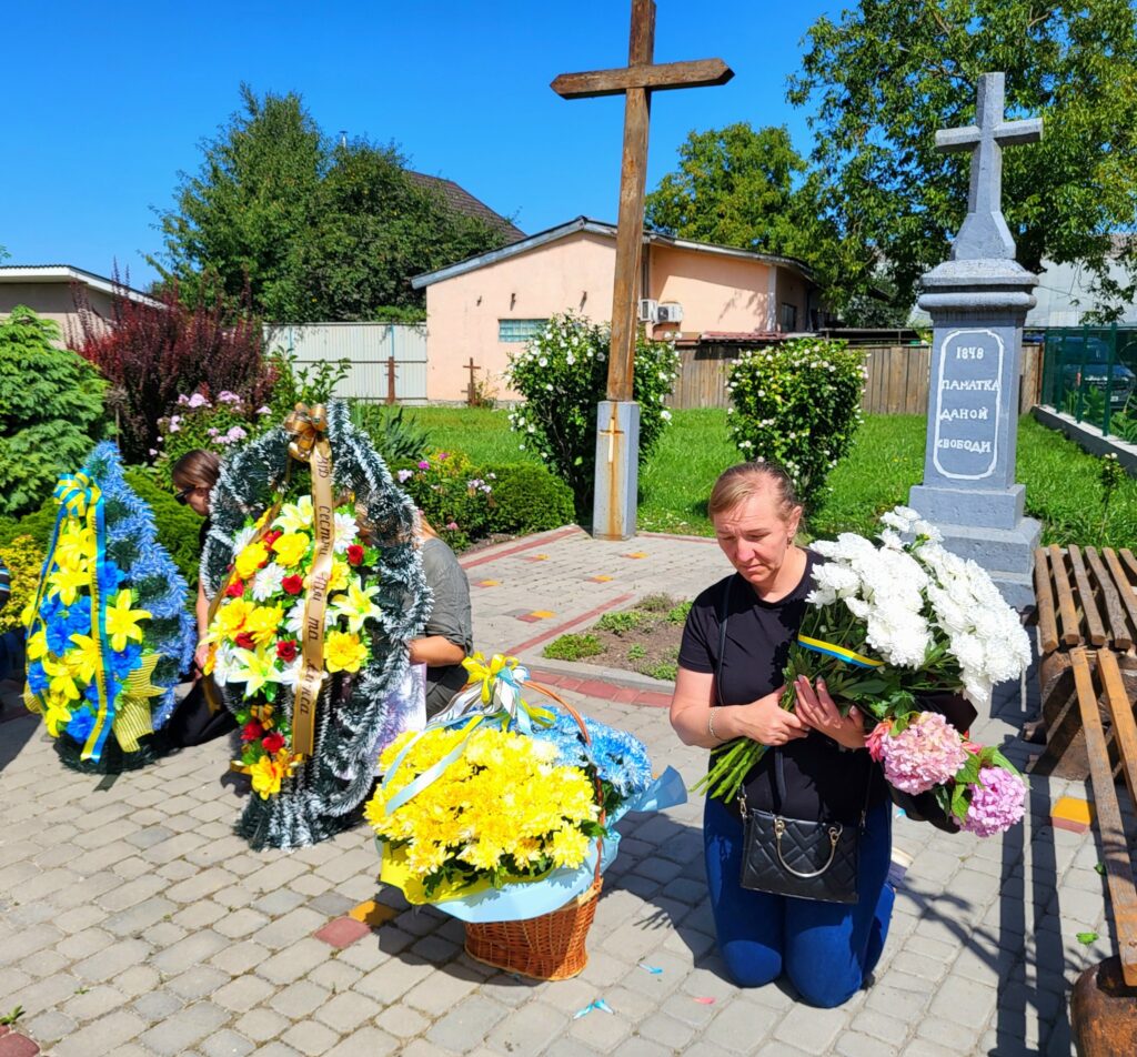 Вшанування пам'яті з квітами на цвинтарі, хрест