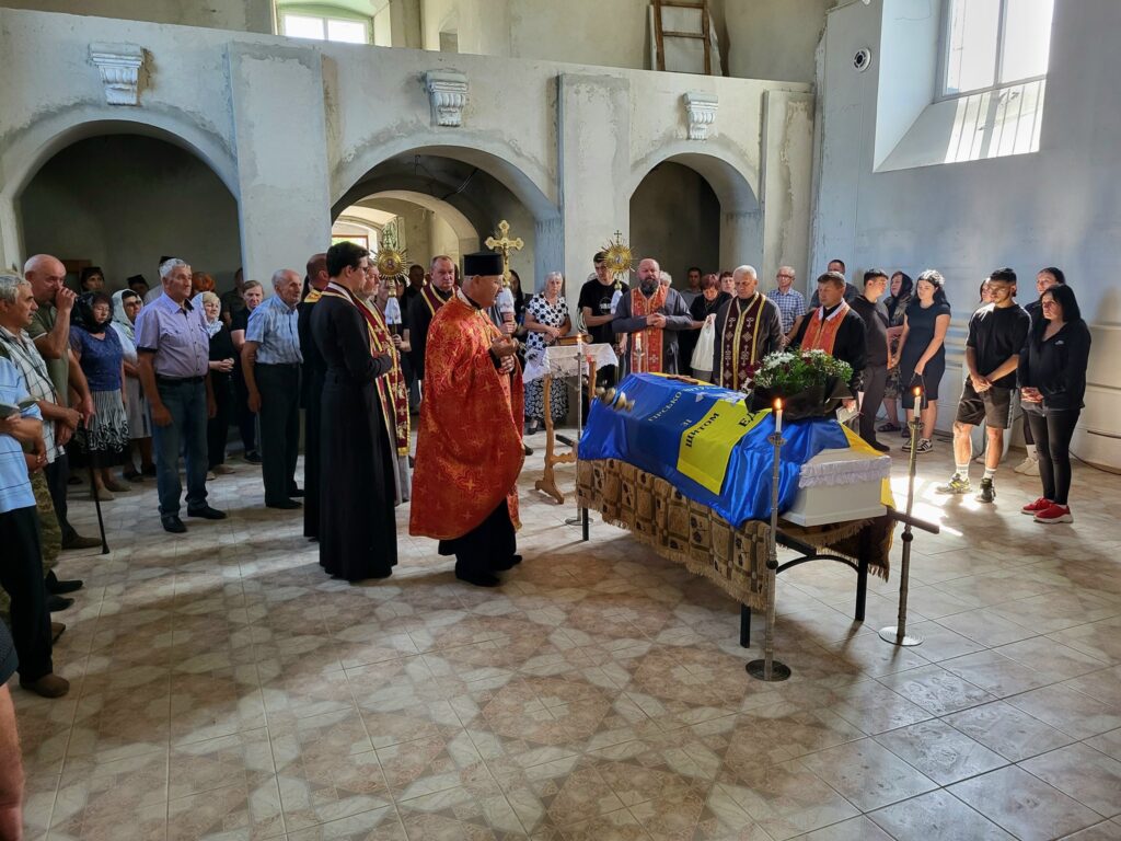 Церковна церемонія з прапором України на труні.