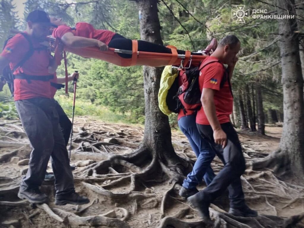 Рятувальники несуть ноші в лісі, Карпати.