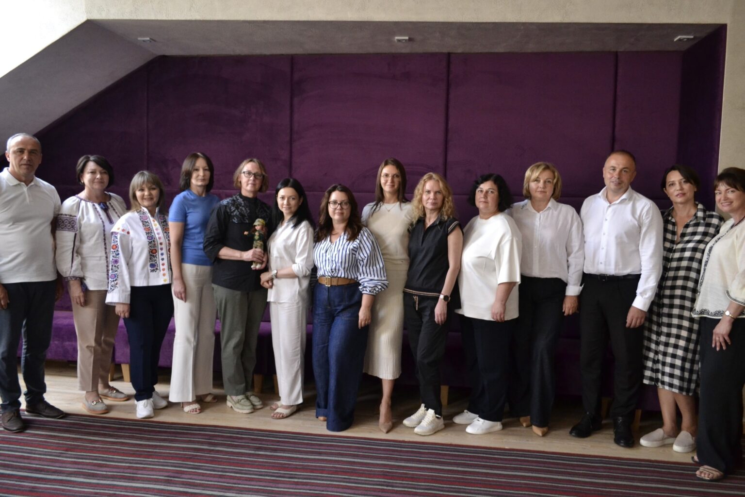 Група людей на фоні фіолетової стіни