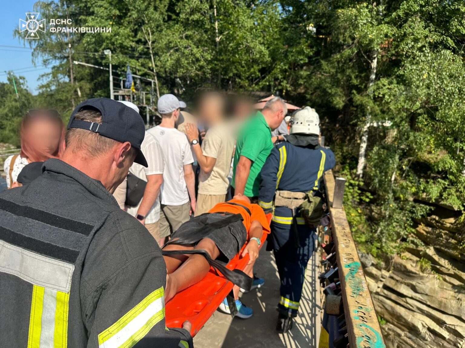 Рятувальники допомагають людині на мосту.