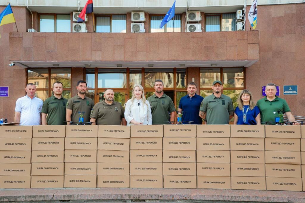Група людей біля коробок 'Шлях до перемоги'.
