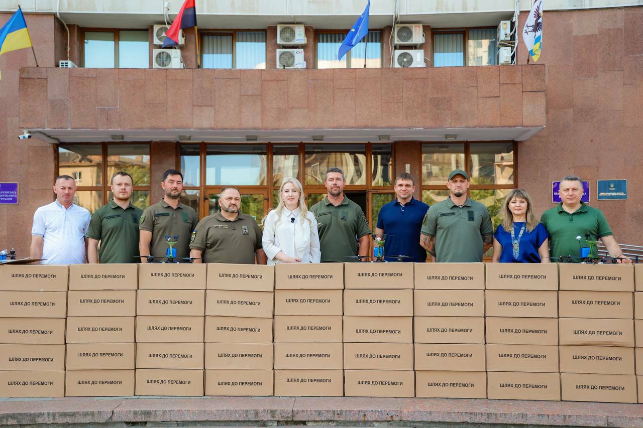 Група людей біля коробок 'Шлях до перемоги'.