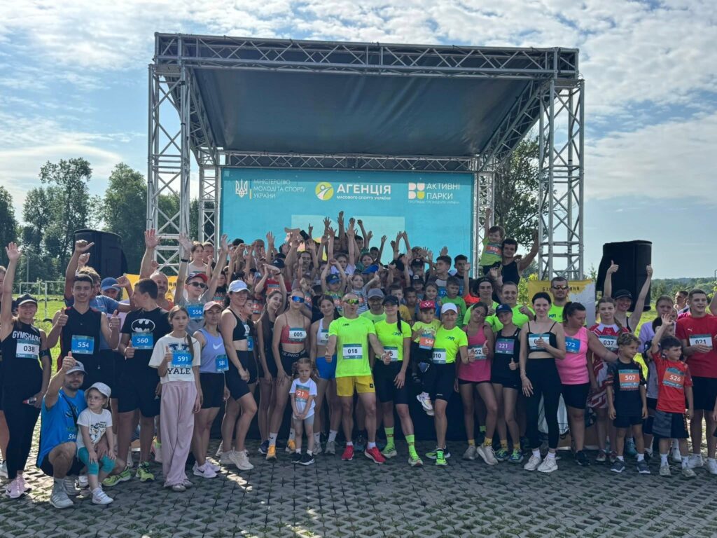 Групове фото учасників спортивного заходу на сцені.