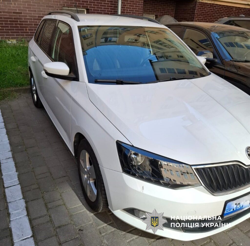 Білий автомобіль біля цегляної будівлі, поліція України.