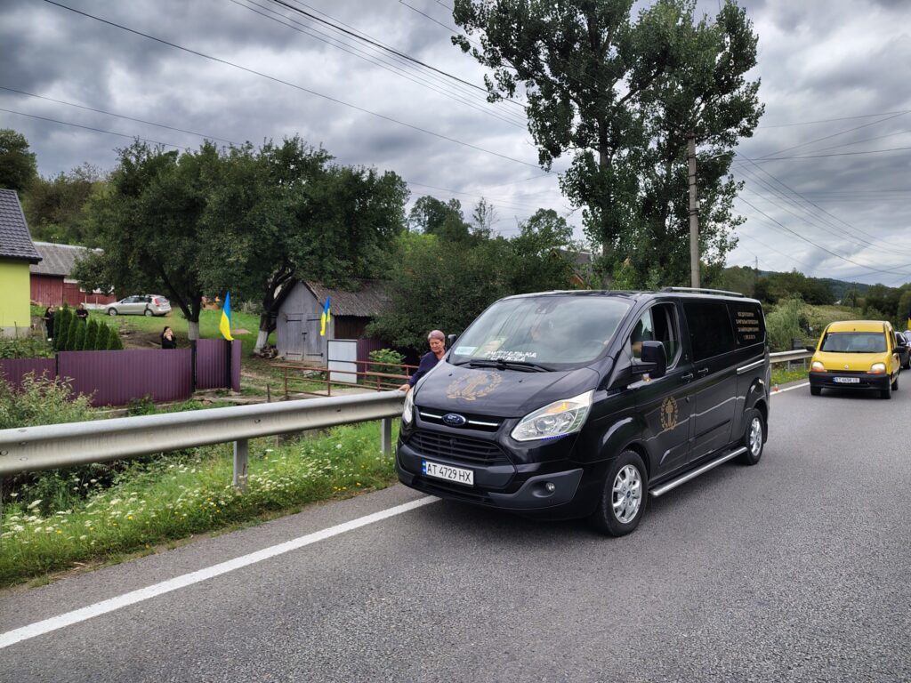 Чорний фургон і жовтий автомобіль на дорозі