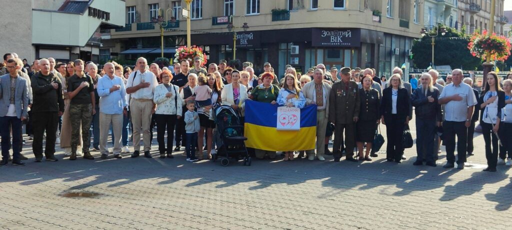 Група людей на площі з прапором України.