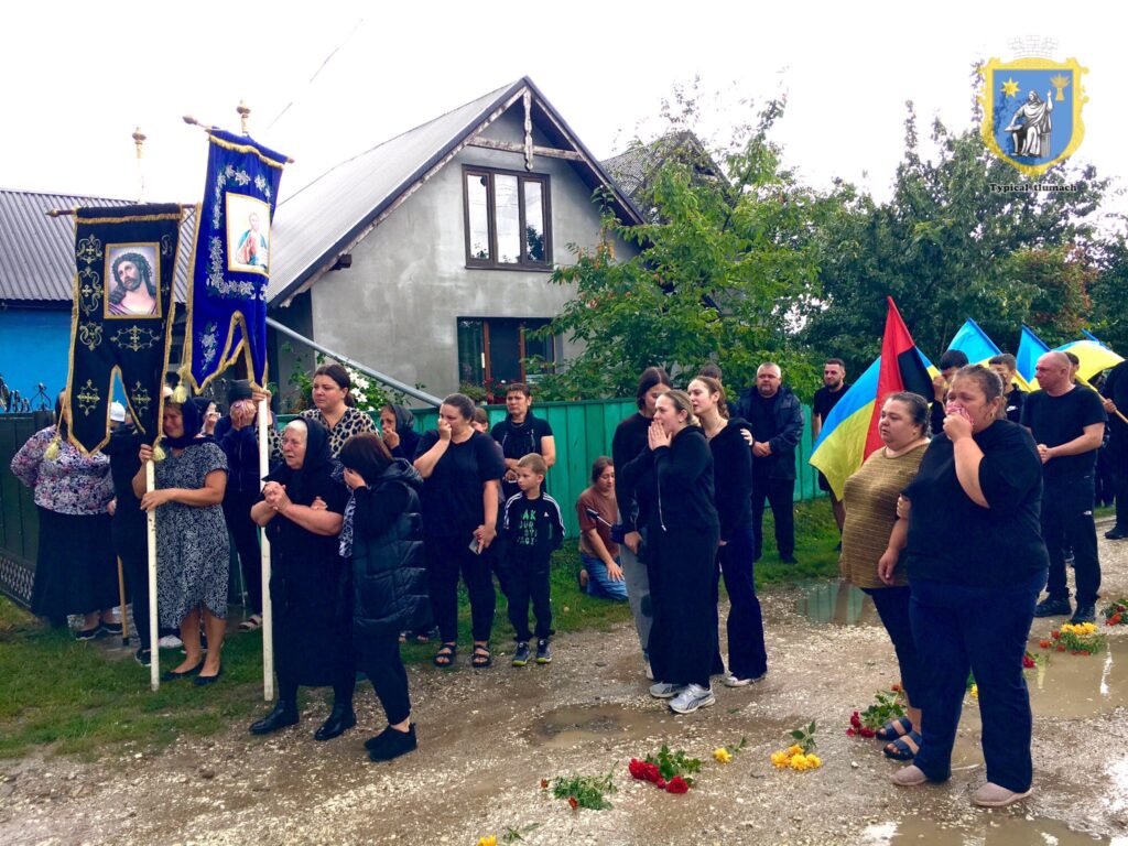 Люди на вулиці з прапорами та іконами, жалоба.