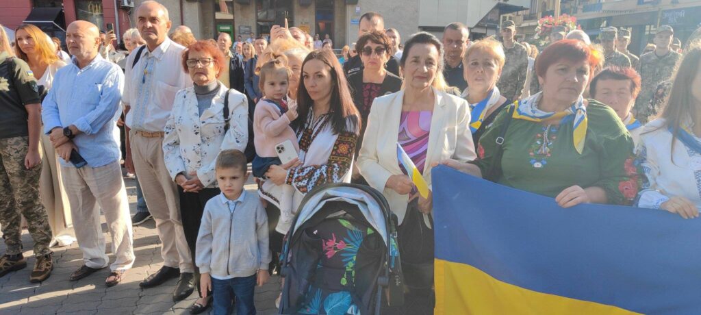 Люди з прапорами на вулиці України.