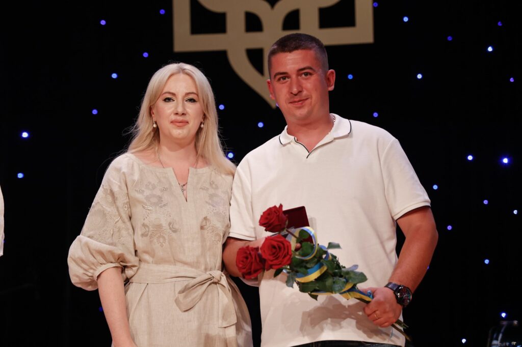 Чоловік і жінка з квітами на сцені.