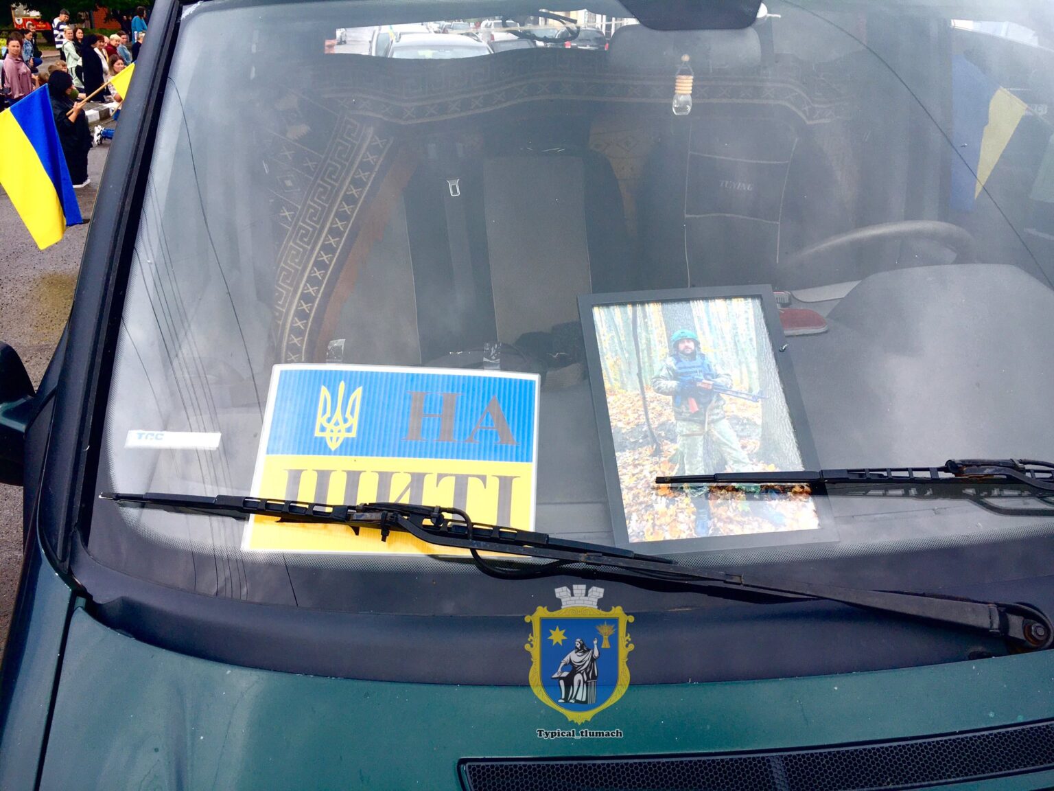 Фотографія військового та прапор України на авто.