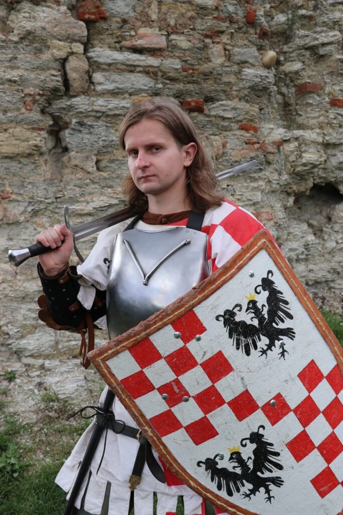 Середньовічний воїн у броні з мечем та щитом
