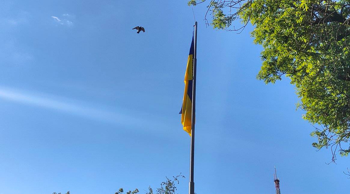 Прапор України на фоні синього неба.