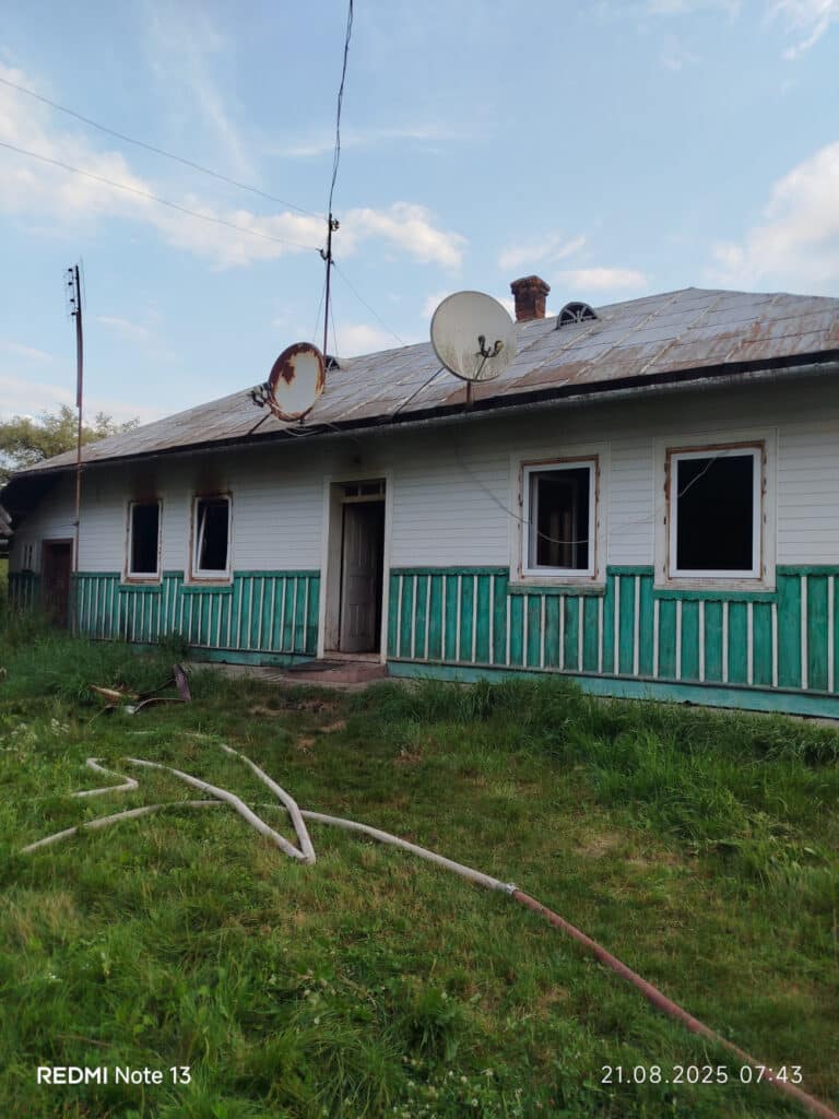 Стара сільська будівля з супутниковими антенами.