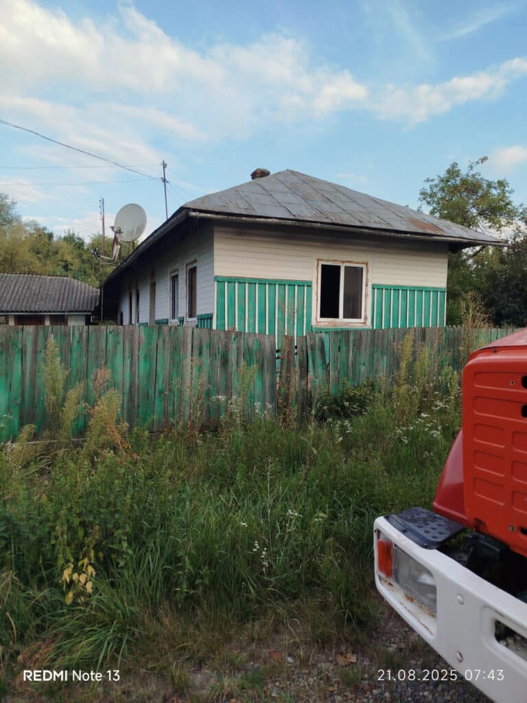 Сільський будинок із супутниковою антеною та парканом