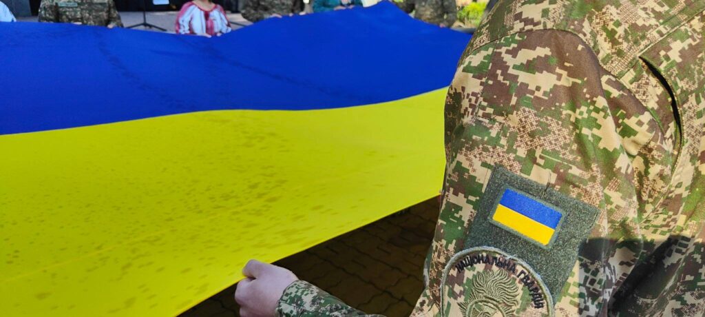 Український прапор і військова форма з шевроном.
