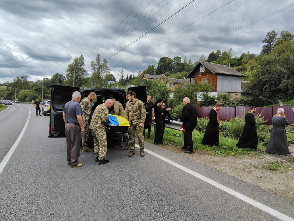 Військові, священики і люди на дорозі.