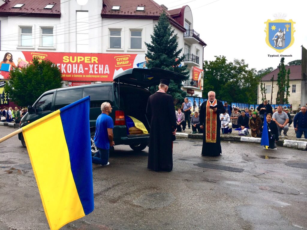 Люди моляться з прапорами на українській площі.