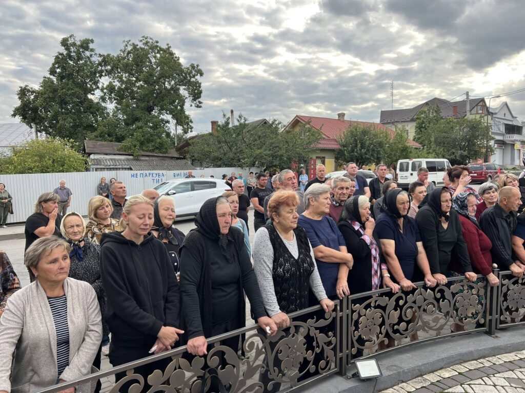Люди на вулиці під похмурим небом.