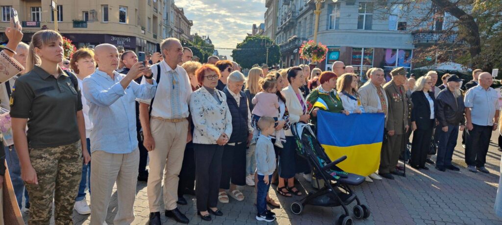 Люди на вулиці з прапором України, міський захід.