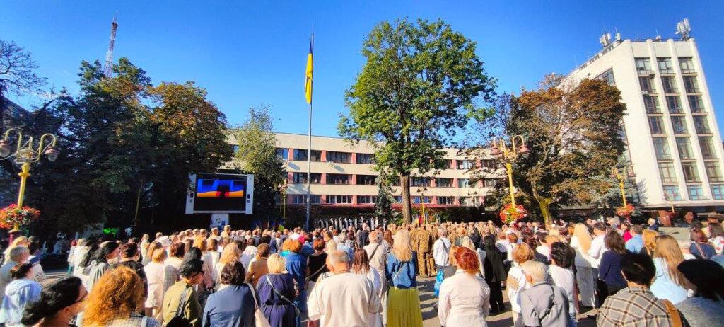 Люди зібрались біля українського прапора на площі.