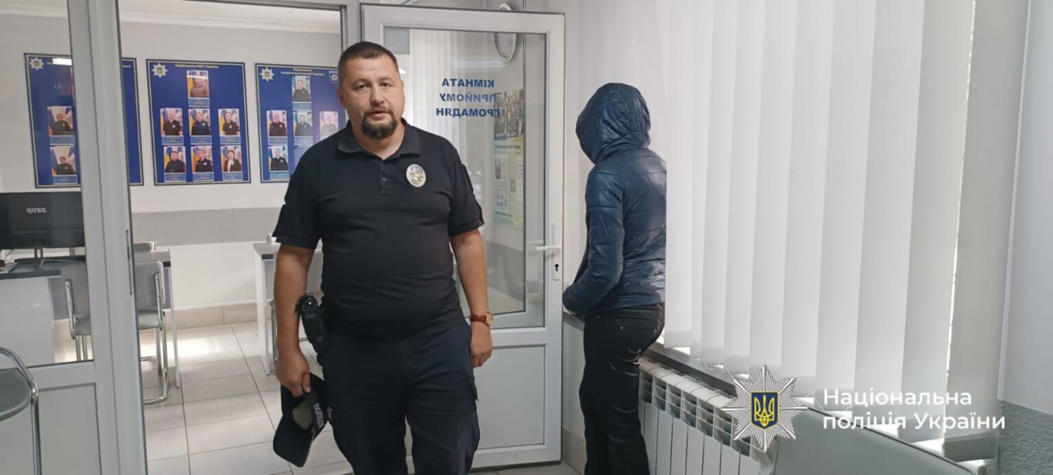 Поліцейський у відділку спілкується з людиною.