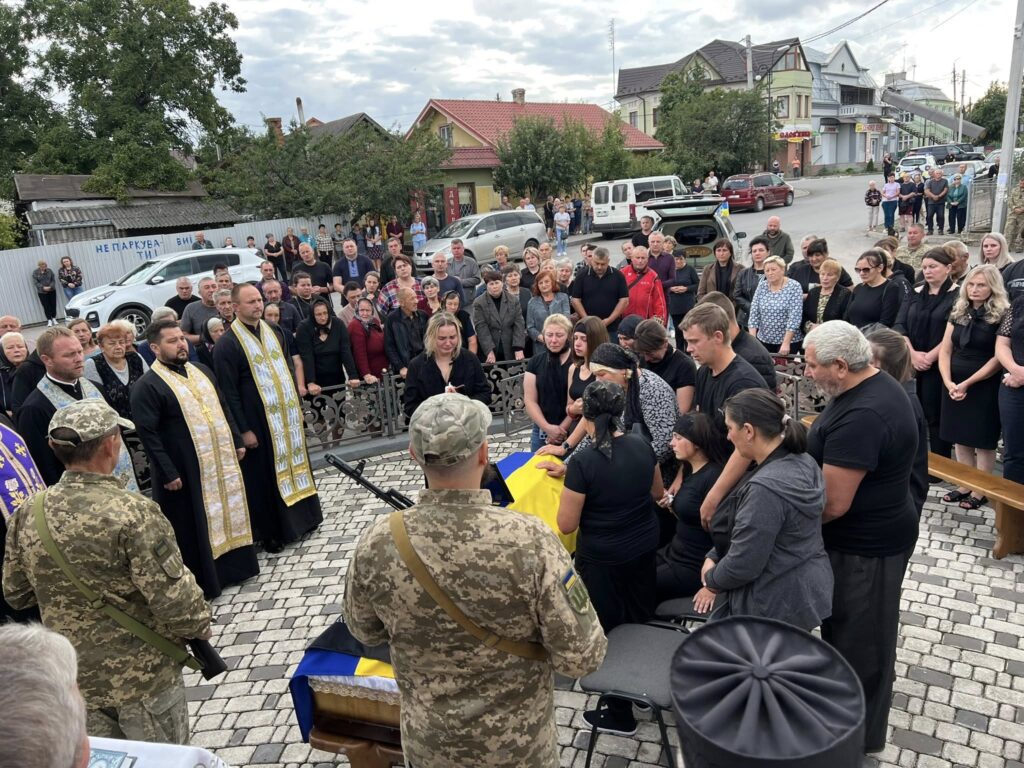Люди на церемонії прощання із загиблим військовим.
