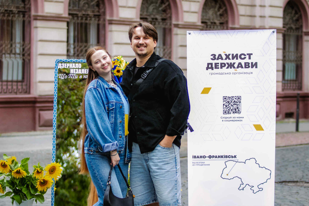 Люди біля банера громадської організації в Івано-Франківську