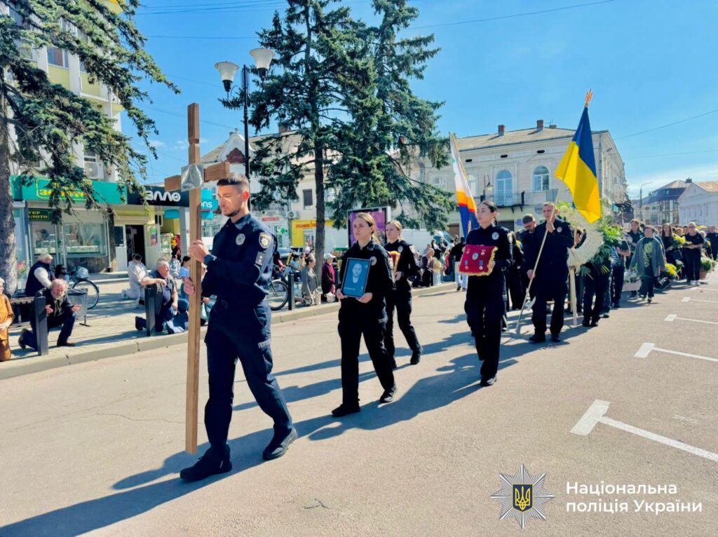 Поліцейська процесія з українським прапором на вулиці.