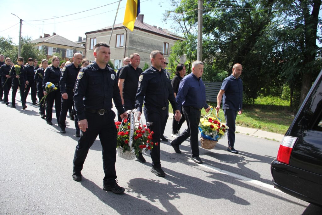 Процесія з поліцією та квітами на вулиці.