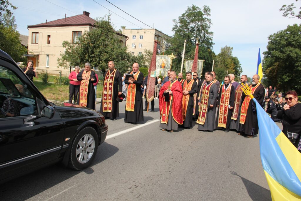 Священики на церковній процесії біля автомобіля