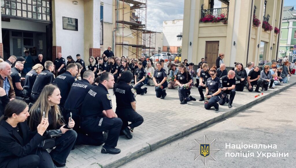 Люди на колінах біля будівлі, поліція України.