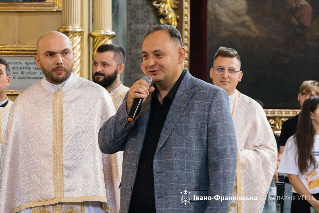 Чоловік з мікрофоном та священники в церкві