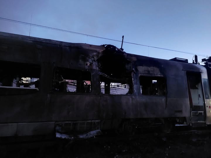 Пошкоджений вагон поїзда на залізниці вночі.