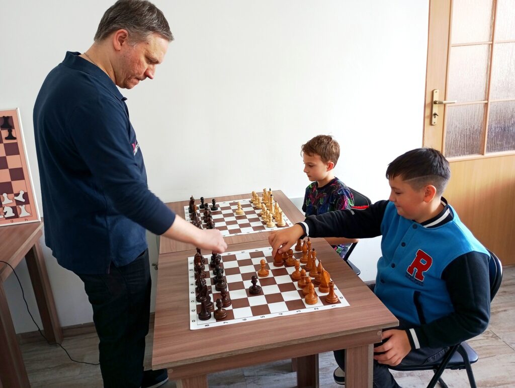 Інструктор проводить урок шахів для дітей.