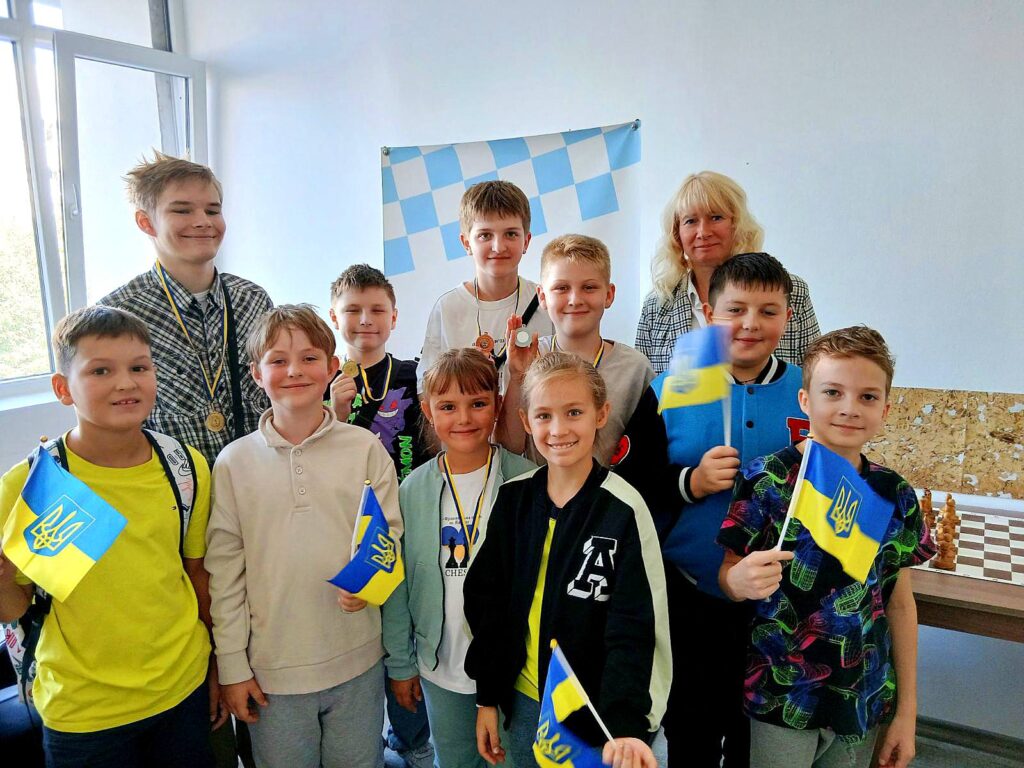 Діти з українськими прапорами на святковому заході.