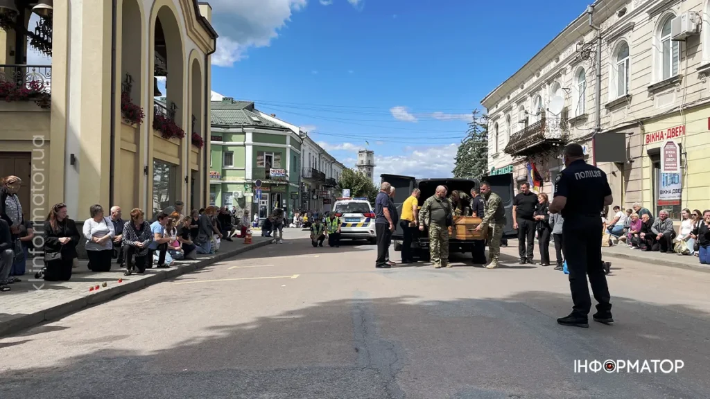 Люди на вулиці з військовим транспортом і поліцією