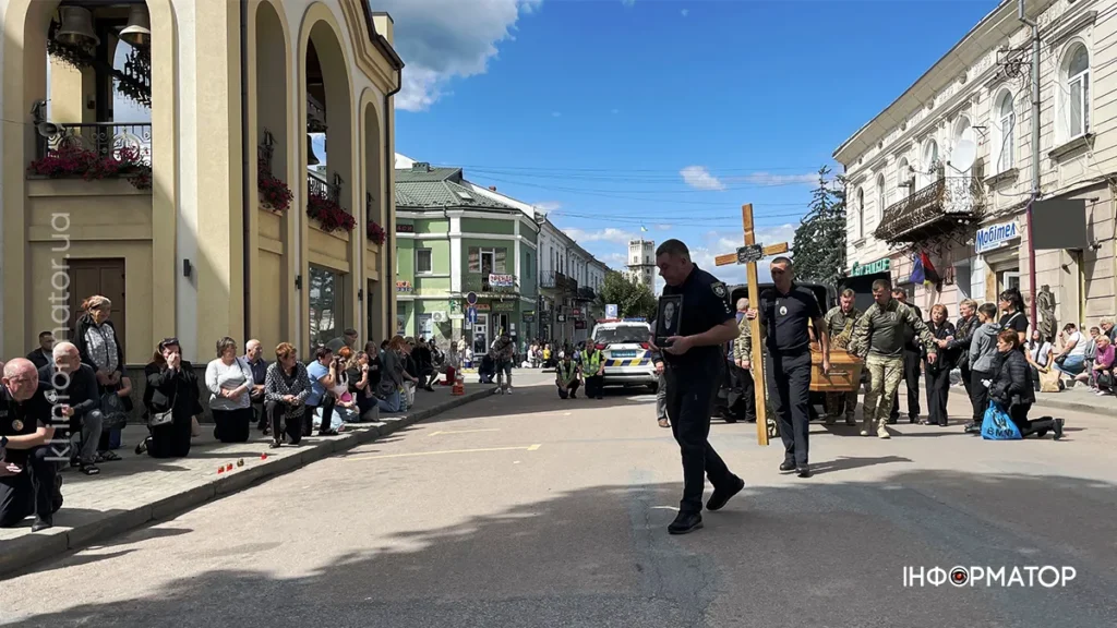 Люди проводжають церемонію на вулиці міста.