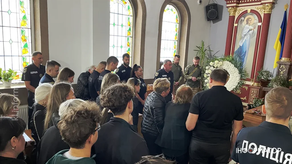 Люди зібралися у церкві біля труни.