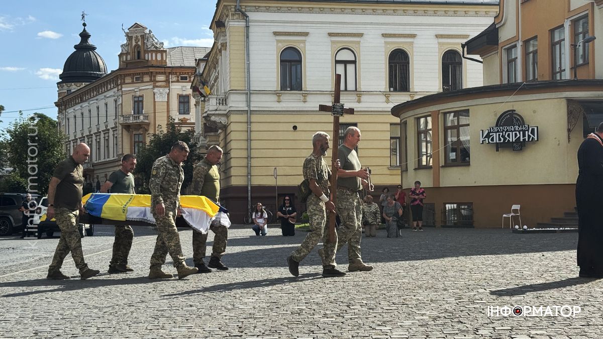Військові несуть труну з українським прапором, центр міста.