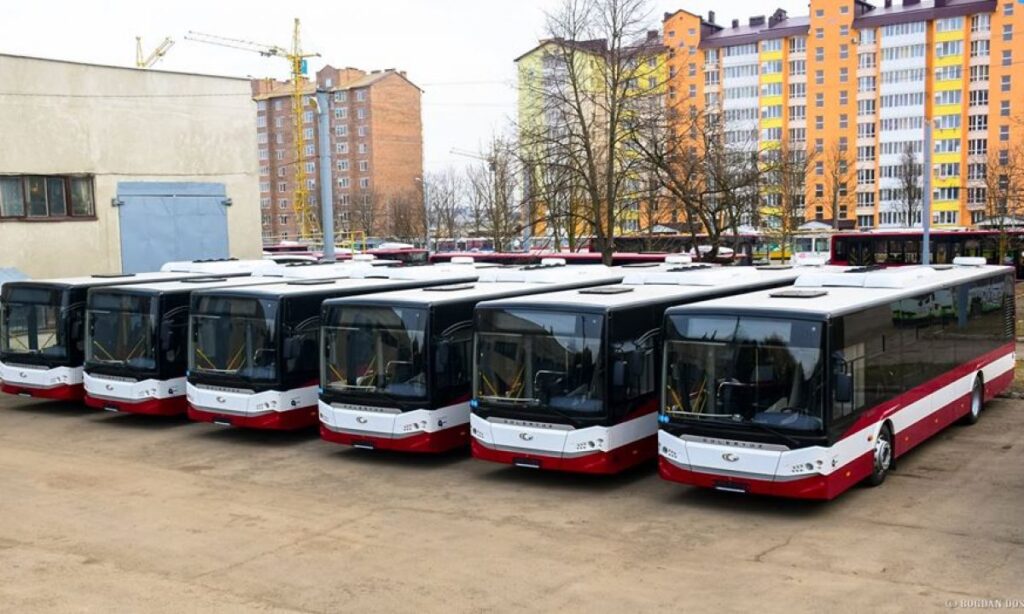 Нові автобуси в депо на фоні будинків