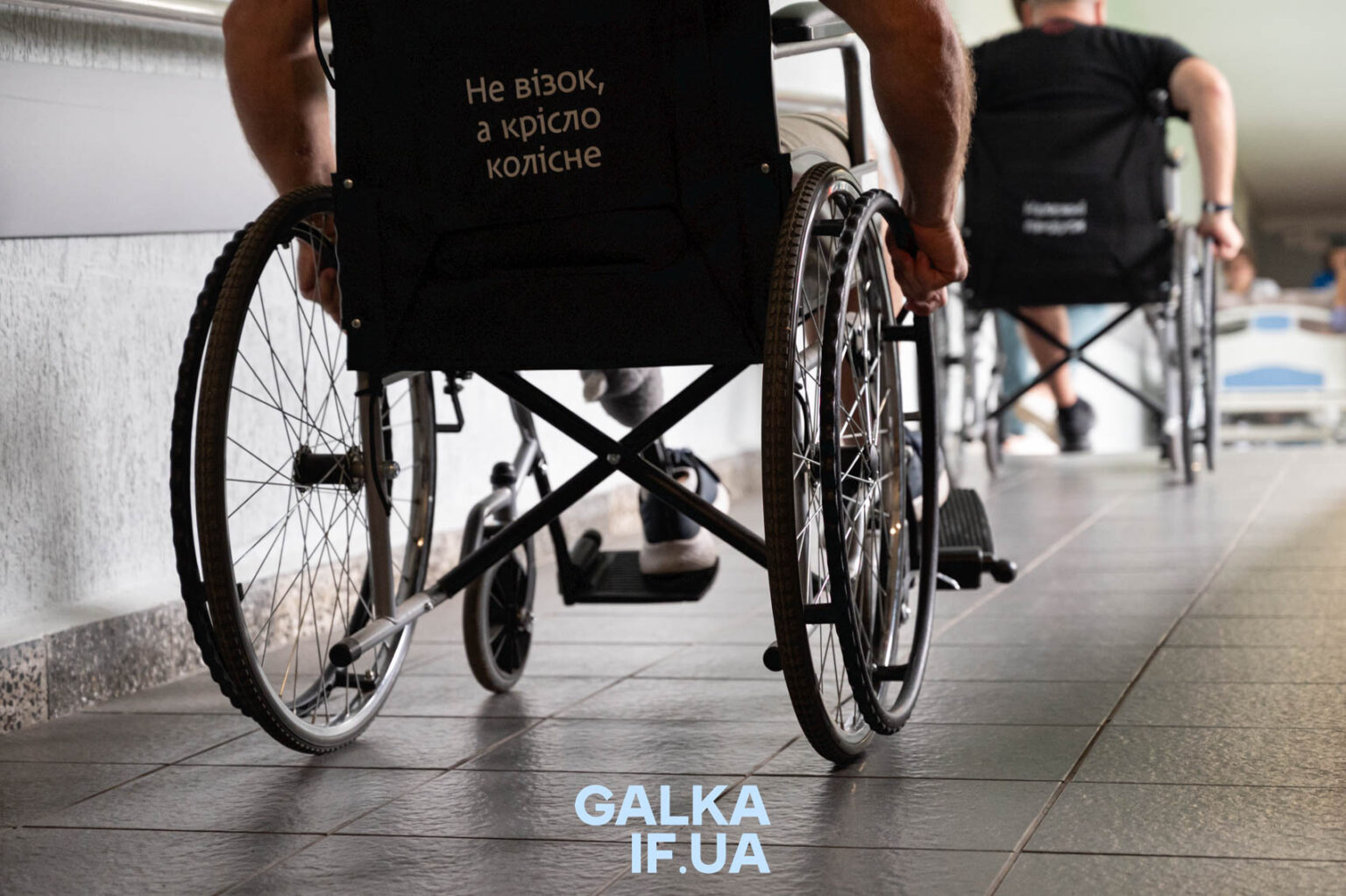 Людина у візку рухається коридором