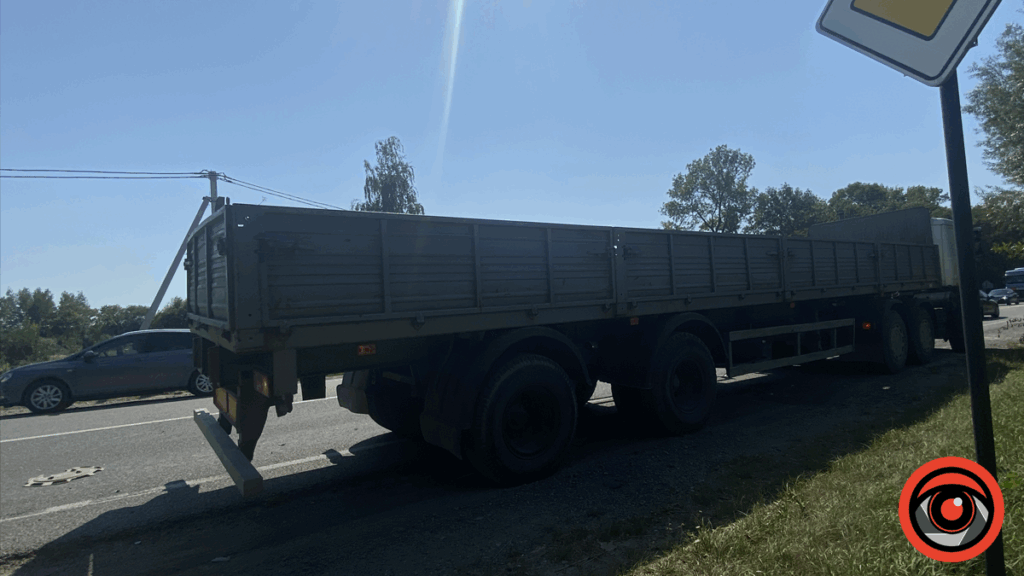 Велика вантажівка на дорозі під ясним небом.