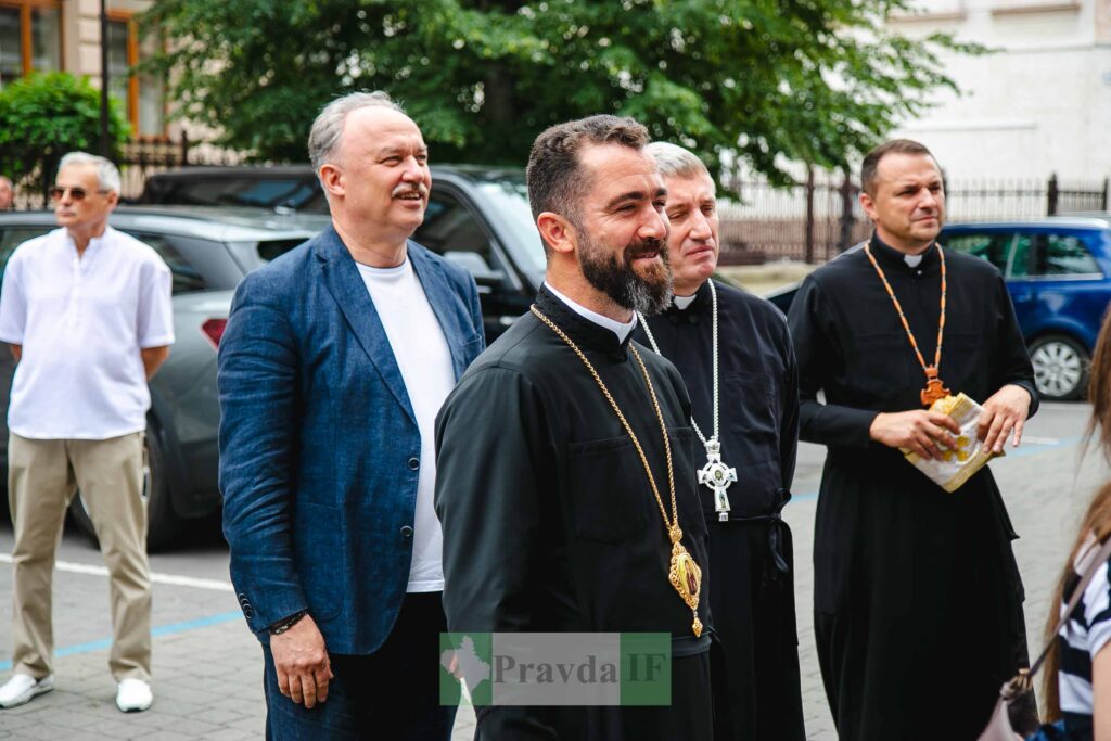 Люди на вулиці, священик у чорній одежі