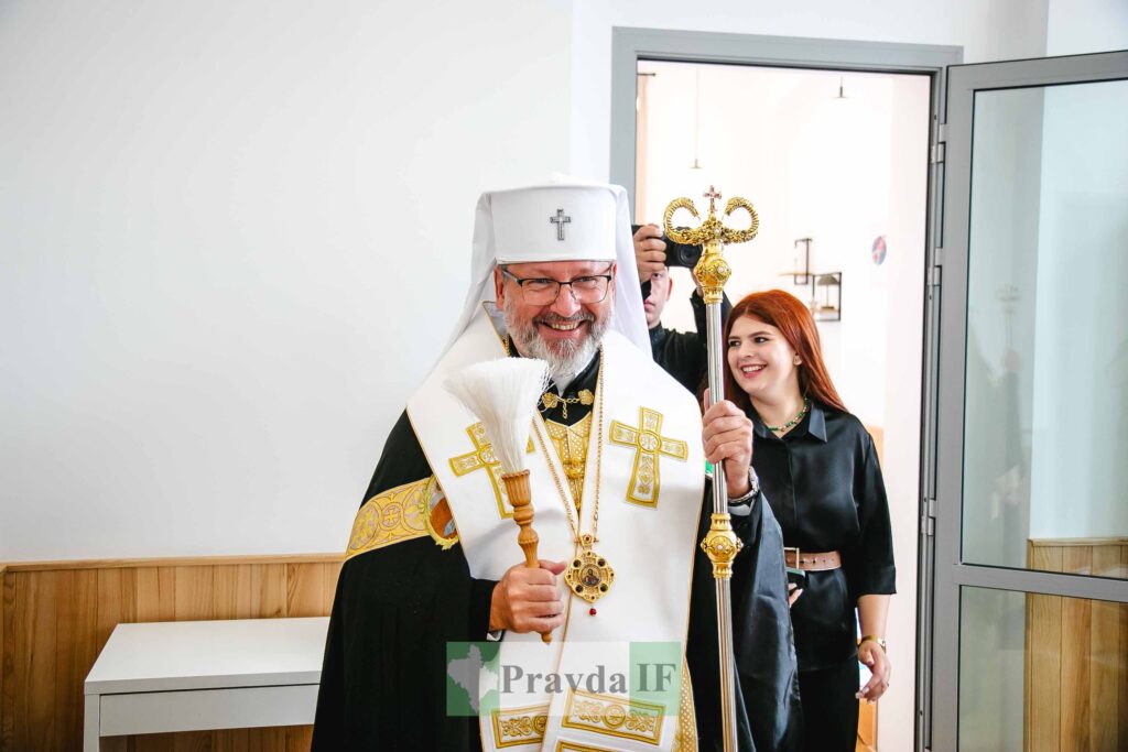 Священник посміхається, стоячи поруч із жінкою