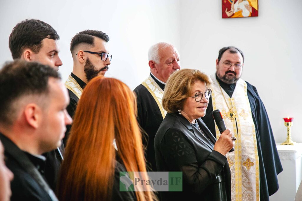 Жінка з мікрофоном на церемонії з духовенством