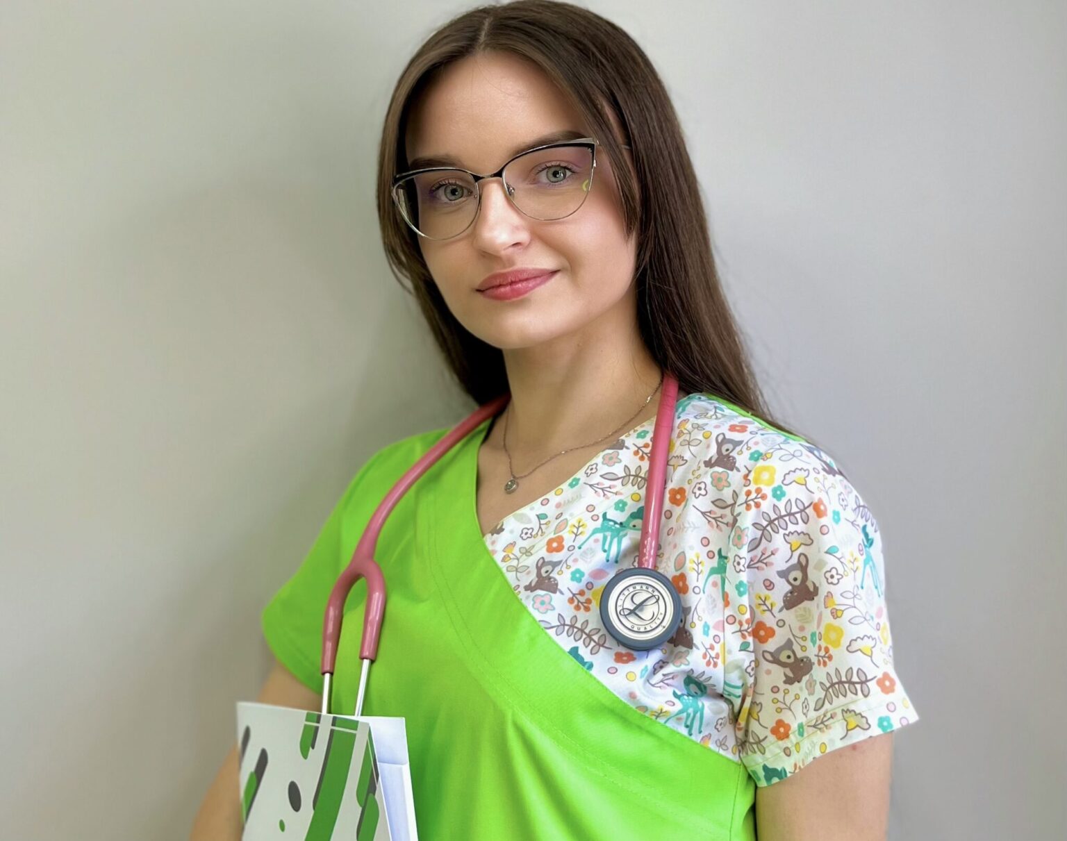 Лікарка з стетоскопом у зеленій уніформі