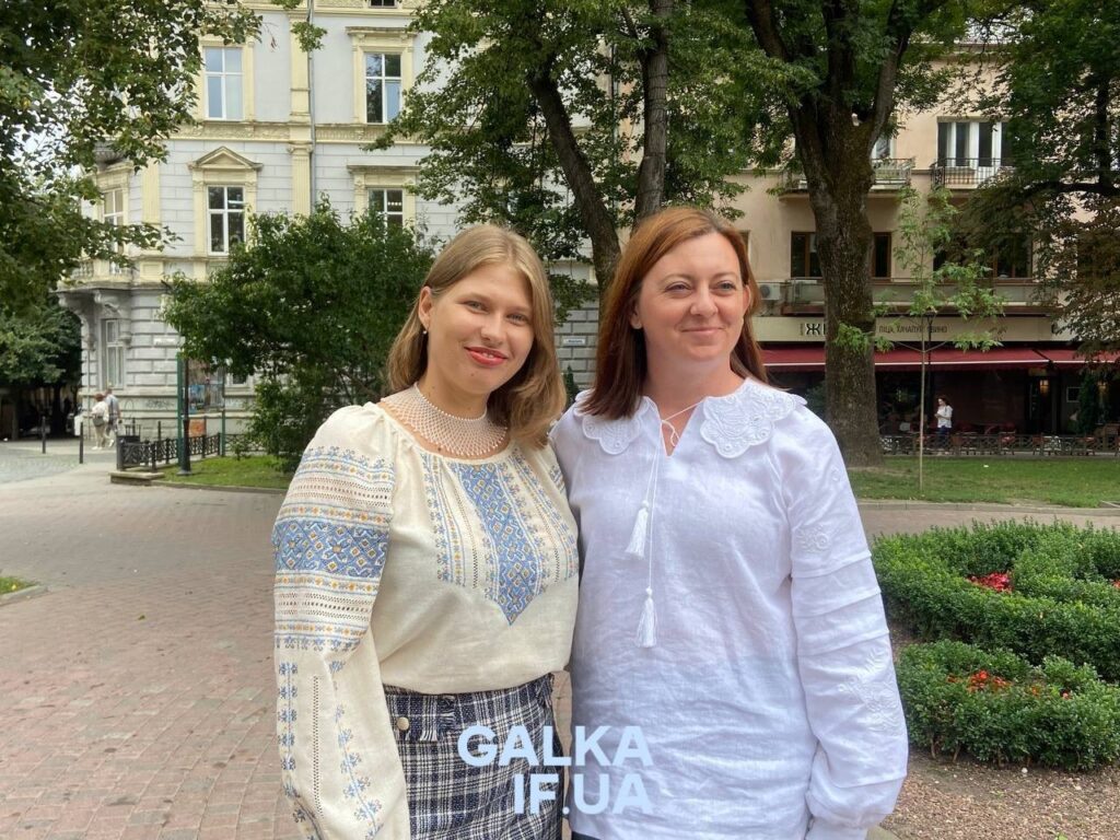 Дві жінки у вишиванках на тлі парку.