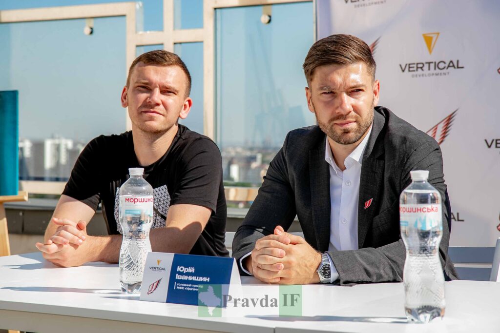 Двоє чоловіків на пресконференції з логотипами Vodka.
